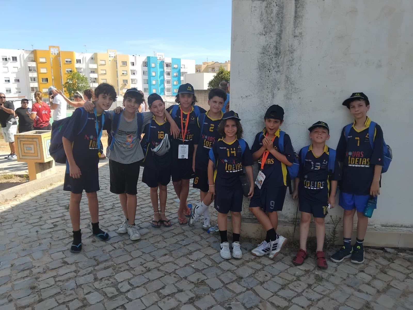 Jovens atletas do Camões Andebol de equipamento azul-escuro e boné do clube